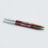 Knitpro-symfonie-2-interchangeable-needle-tips-special-10cm - Two 5.0mm US8 knitting needles with metallic silver tips and colorful wooden shafts showing red, green, and brown grain, on a light gray background.